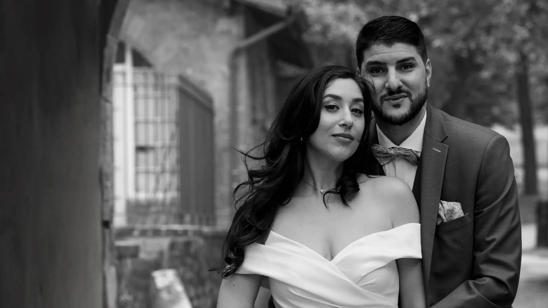 Portrait élégant en noir et blanc d'un couple de jeunes mariés regardant l'objectif
